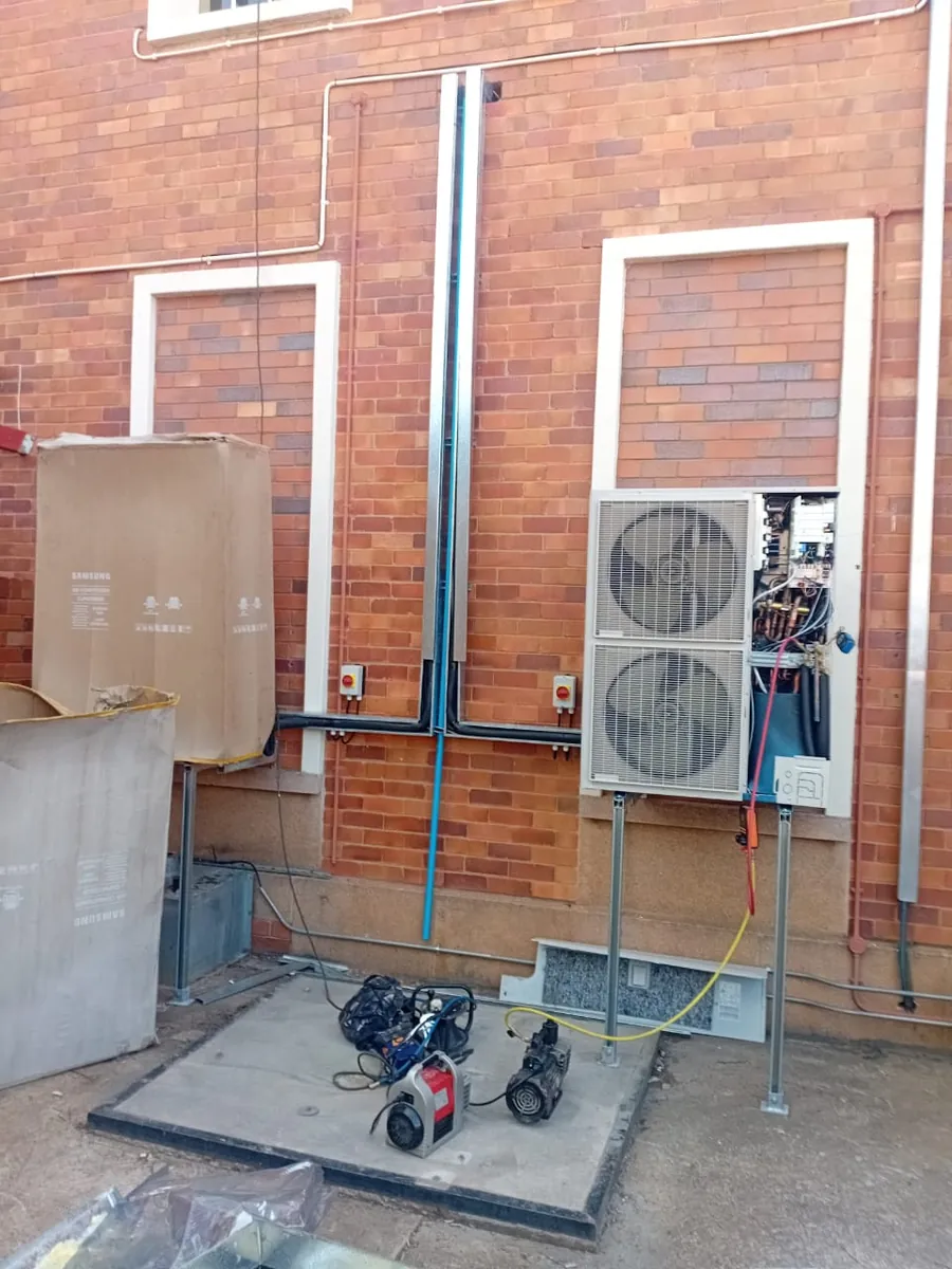 Outdoor unit being installed, with a vacuum pump and gauges connected
